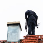 Chimney,Sweep,Standing,On,Roof,Of,Home,Working