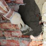 A,Professional,Builder,Bricklayer,With,Hand,Trowel,Applies,Cement,Mortar